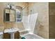 A tiled bathroom includes a tub, toilet, sink and window at 1258 N Downing St, Denver, CO 80218
