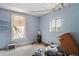 A blue bedroom shows two windows, some shelving, and clutter on the floor at 1258 N Downing St, Denver, CO 80218