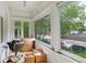 A sunroom with large windows overlooks the street, and the room is cluttered with boxes and an office chair at 1258 N Downing St, Denver, CO 80218