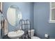 Small bathroom with pedestal sink, toilet, and a stylish oval mirror at 10983 Memphis St, Commerce City, CO 80022