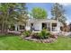 Manicured backyard with mature trees and a stone-lined flower bed at 6075 S Filbert Ct, Centennial, CO 80121