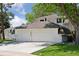 Angle view of charming home featuring mature trees, green lawn, and a spacious three-car garage at 6075 S Filbert Ct, Centennial, CO 80121