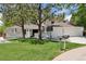 Charming home featuring mature trees, green lawn, and a spacious three-car garage at 6075 S Filbert Ct, Centennial, CO 80121