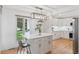 Bright kitchen island features white countertops and cabinets, bar stool seating, and modern lighting at 6075 S Filbert Ct, Centennial, CO 80121