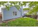 Lush backyard featuring green lawn, brick-lined edge, patio seating, privacy fence, and light blue siding at 12060 N Holly Way, Brighton, CO 80602