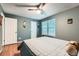 Comfortable bedroom featuring wood floors, a ceiling fan, a large window, and a bed with a warm blanket at 12060 N Holly Way, Brighton, CO 80602