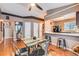 Open dining room featuring a view into the kitchen, wood floors, and a modern table at 12060 N Holly Way, Brighton, CO 80602