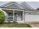 Charming home with light-blue siding, porch, well-maintained lawn, and an attached two car garage at 12060 N Holly Way, Brighton, CO 80602