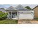 Charming exterior featuring blue siding, a front porch, an attached garage, and well-maintained landscaping at 12060 N Holly Way, Brighton, CO 80602
