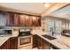 Modern kitchen with stainless steel appliances, granite countertops, and a breakfast bar at 12060 N Holly Way, Brighton, CO 80602