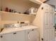 This laundry room features a newer model Maytag washer and dryer and shelving for supplies at 12060 N Holly Way, Brighton, CO 80602