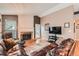 Comfortable living room featuring a brick fireplace, wood floors, and a leather sectional sofa at 12060 N Holly Way, Brighton, CO 80602