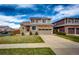 Two-story home featuring stone accents, a two-car garage, a red door, and a well-maintained front lawn at 20305 E 41St Ave, Denver, CO 80249