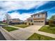 Two-story home with a stone facade, a paved driveway, and solar panels at 20305 E 41St Ave, Denver, CO 80249
