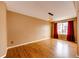 Well-lit living room with hardwood floors, neutral walls, and a window with red curtains at 20305 E 41St Ave, Denver, CO 80249