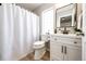 Bathroom featuring modern vanity, white cabinet, updated fixtures, toilet, and shower with white curtain at 1786 Quartz St, Castle Rock, CO 80109