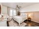 Cozy bedroom with neutral colors, a ceiling fan, and a comfortable armchair next to a sunny window at 1786 Quartz St, Castle Rock, CO 80109