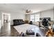 Bright living room with dark hardwood floors, ceiling fan, neutral paint, leather furniture and large windows at 1786 Quartz St, Castle Rock, CO 80109