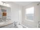 Bright bathroom with a bathtub, tile surround, and a modern vanity with good lighting at 3028 N Gilpin St, Denver, CO 80205
