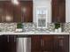 Modern kitchen featuring dark cabinets, stainless steel appliances, and tile backsplash at 3028 N Gilpin St, Denver, CO 80205
