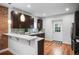 Modern kitchen featuring dark cabinets, breakfast bar, stainless steel appliances at 3028 N Gilpin St, Denver, CO 80205
