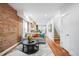 Bright living room featuring exposed brick wall, hardwood floors, and modern decor at 3028 N Gilpin St, Denver, CO 80205