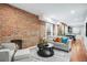 Cozy living room featuring exposed brick wall, fireplace, and stylish decor at 3028 N Gilpin St, Denver, CO 80205