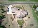 An aerial view of a home with beautiful landscaping, a fire pit, and a circular driveway at 5195 Raintree Cir, Parker, CO 80134