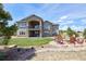 A home with a patio, balcony, stone details, and backyard fire pit and seating area at 5195 Raintree Cir, Parker, CO 80134