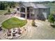 A spacious backyard featuring a fire pit surrounded by seating and a large grassy area at 5195 Raintree Cir, Parker, CO 80134