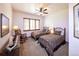 Cozy bedroom with two beds, a ceiling fan, wooden blinds, and a rocking chair at 5195 Raintree Cir, Parker, CO 80134