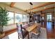 Open concept dining room flows to the kitchen with rustic wood table and large picture window at 5195 Raintree Cir, Parker, CO 80134