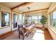 Bright dining room featuring rustic wood table, exposed beams, and large windows with scenic views at 5195 Raintree Cir, Parker, CO 80134