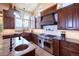 Close-up of the chef's kitchen with a large Wolf range and sink with granite counters at 5195 Raintree Cir, Parker, CO 80134