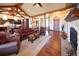 Bright living room with hardwood floors, stone fireplace, and open view to the kitchen at 5195 Raintree Cir, Parker, CO 80134
