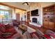 Spacious living room with hardwood floors, stone fireplace, and views of the outdoor scenery at 5195 Raintree Cir, Parker, CO 80134