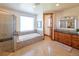 Spacious bathroom featuring a walk-in shower, soaking tub, and wooden cabinets at 5195 Raintree Cir, Parker, CO 80134