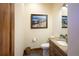 Small powder room featuring wood cabinets, granite countertop, and tile flooring at 5195 Raintree Cir, Parker, CO 80134