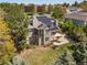 Aerial perspective showcases a home with solar panels and a backyard patio, nestled among mature trees at 8833 Maplewood Dr, Highlands Ranch, CO 80126