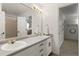 Bright bathroom featuring a double vanity, neutral finishes and a separate tub/shower room at 8833 Maplewood Dr, Highlands Ranch, CO 80126