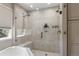 Gorgeous walk-in shower features dual showerheads, bench seating, and custom tile work at 8833 Maplewood Dr, Highlands Ranch, CO 80126