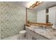 Charming bathroom with a granite countertop vanity, decorative wallpaper, and stylish light fixture at 8833 Maplewood Dr, Highlands Ranch, CO 80126