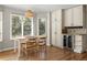Sunlit dining area features hardwood flooring, cabinets, wine storage, and large windows at 8833 Maplewood Dr, Highlands Ranch, CO 80126