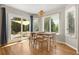 Open dining area with hardwood floors, a pendant light, and sliding glass doors to a covered patio at 8833 Maplewood Dr, Highlands Ranch, CO 80126