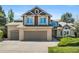 Charming two-story home featuring a brick and siding facade, a three-car garage, and manicured landscaping at 8833 Maplewood Dr, Highlands Ranch, CO 80126