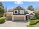 Charming two-story home featuring a brick and siding facade, a three-car garage, and manicured landscaping at 8833 Maplewood Dr, Highlands Ranch, CO 80126