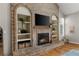 Close-up of the living room's stunning brick fireplace with built-in shelving and a cozy ambiance at 8833 Maplewood Dr, Highlands Ranch, CO 80126