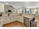 Open kitchen with stone countertops, stainless steel dishwasher, natural lighting, and hardwood floors at 8833 Maplewood Dr, Highlands Ranch, CO 80126
