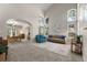 Bright living room with high ceilings, large windows, comfortable seating, and an open archway to the dining area at 8833 Maplewood Dr, Highlands Ranch, CO 80126