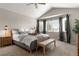Bright main bedroom with vaulted ceiling, bay windows, and a comfortable seating area at 8833 Maplewood Dr, Highlands Ranch, CO 80126